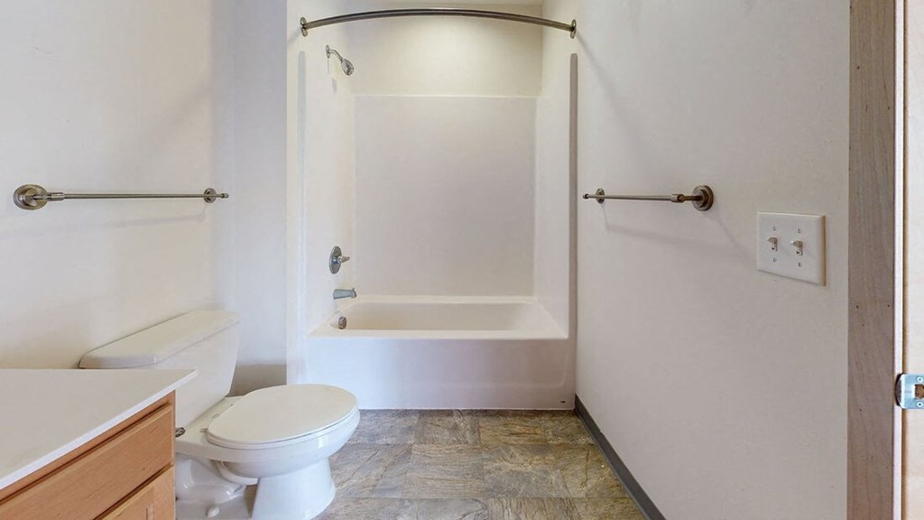 a bathroom with a toilet and a tub and a sink