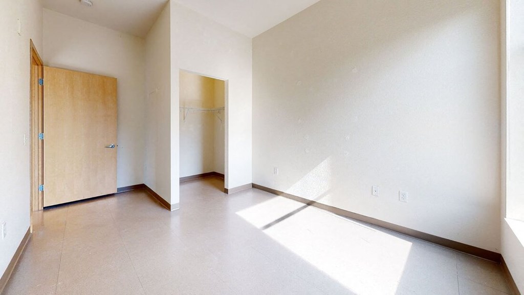 an empty living room with a door to a closet