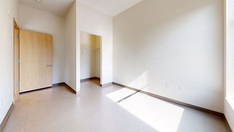 an empty living room with a door to a closet