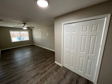 A room with a white door and a ceiling fan.