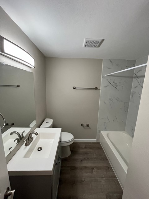 A bathroom with a white sink and a toilet.