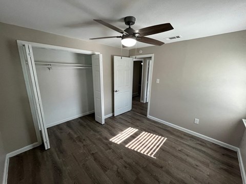 A room with a ceiling fan and a white door.