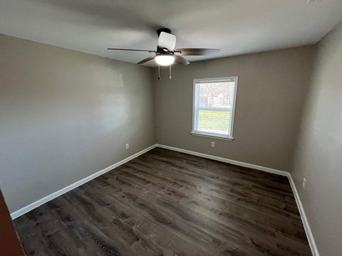 A room with a ceiling fan and a window.