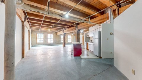 an empty room with a refrigerator in the middle of it