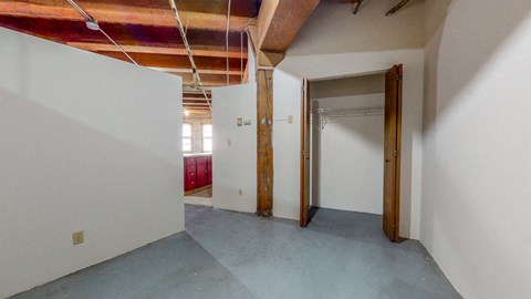 an empty room with white walls and a door to a closet