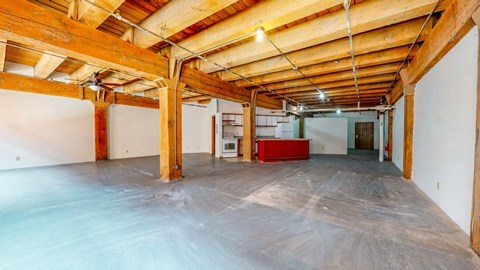 an empty room with a red couch in the corner of it