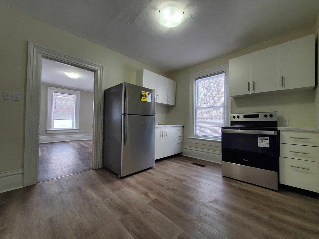 a kitchen with a refrigerator and a stove and a window