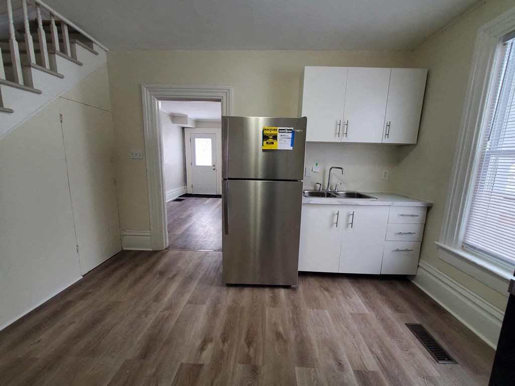 a kitchen with white cabinets and a stainless steel refrigerator