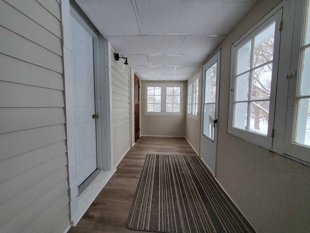a long hallway with many windows and a rug on the floor