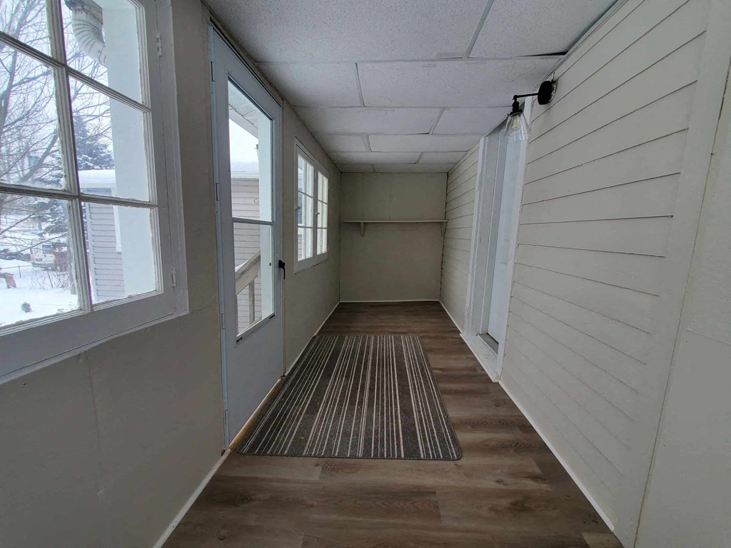 a long hallway with windows and a rug on the floor