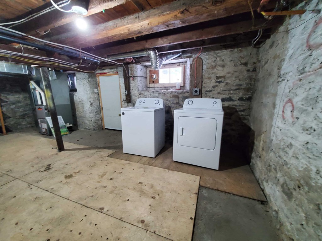 two washer and dryers in the basement of a house