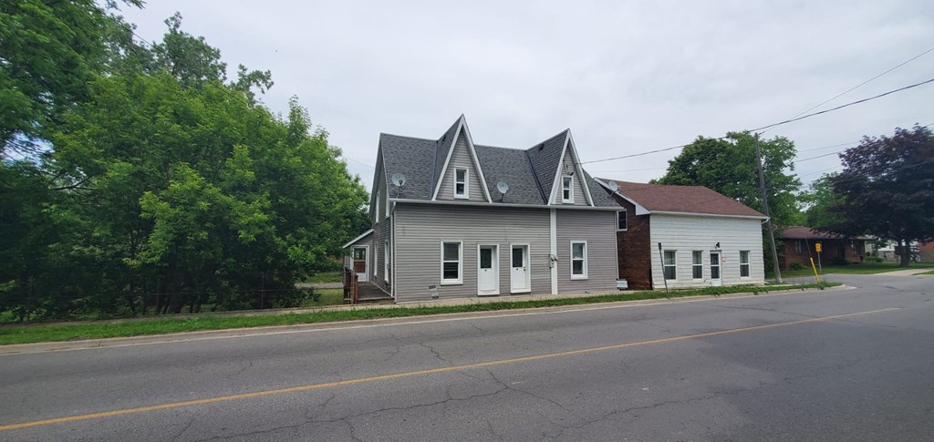 a house with a triangular roof on the side of a street