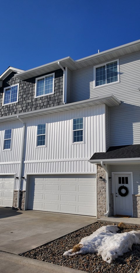 a white house with a garage door in front of it