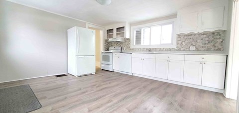 A kitchen with white appliances and cabinets.