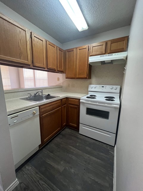A kitchen with wooden cabinets and white appliances.