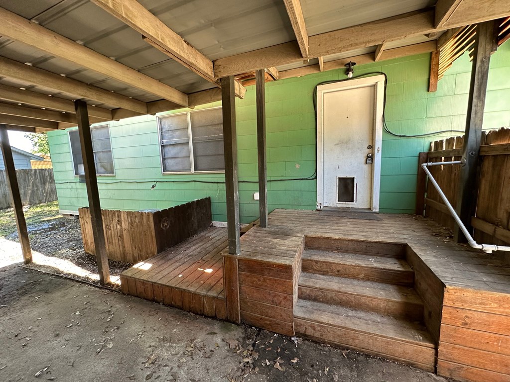the porch of an abandoned building with wooden steps and a door