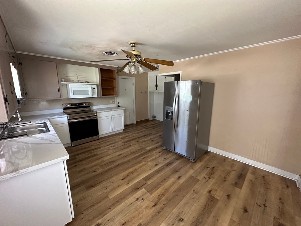 a kitchen with a stainless steel refrigerator and a ceiling fan