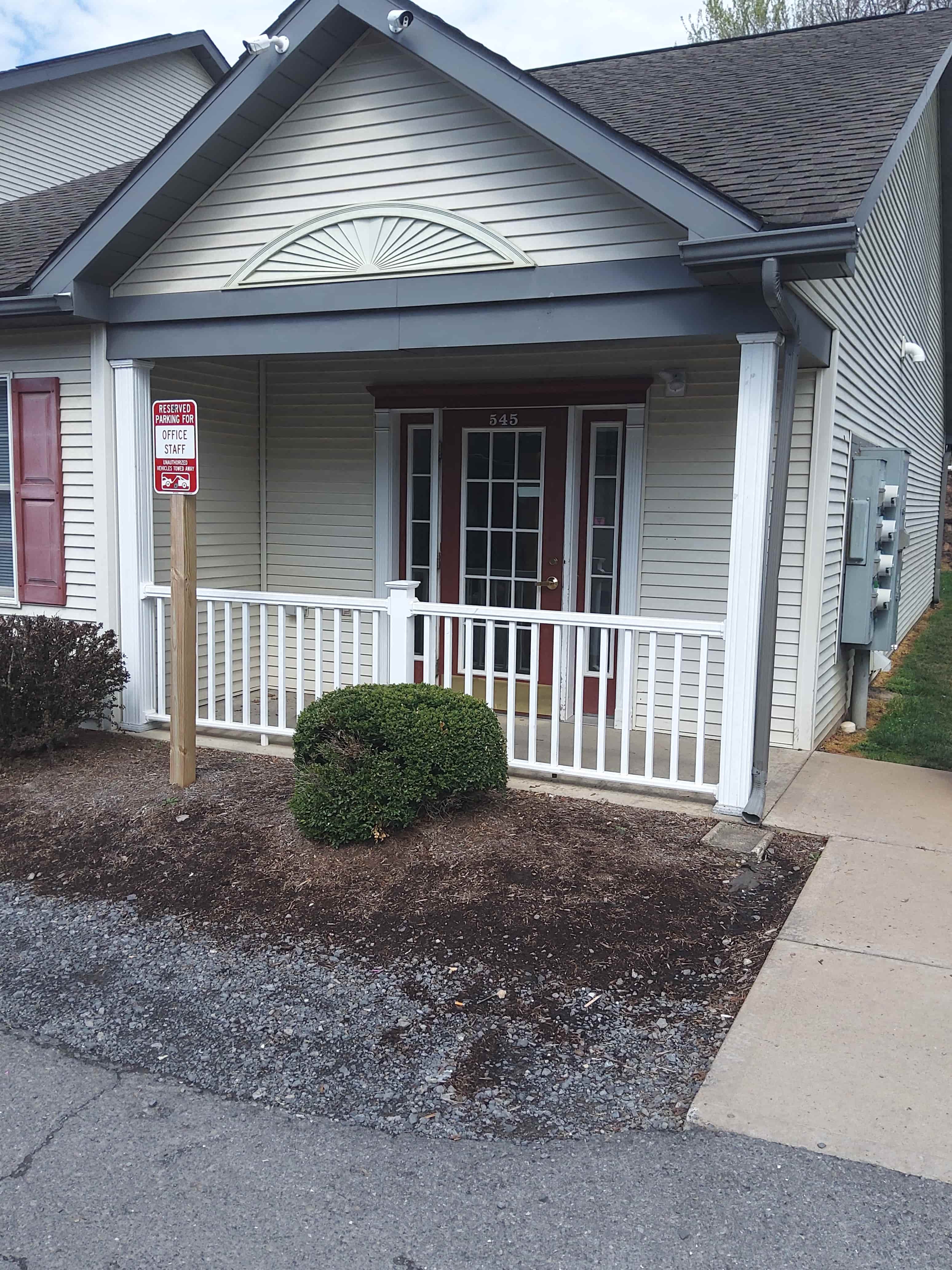 a house with a porch and a sign on the side of it