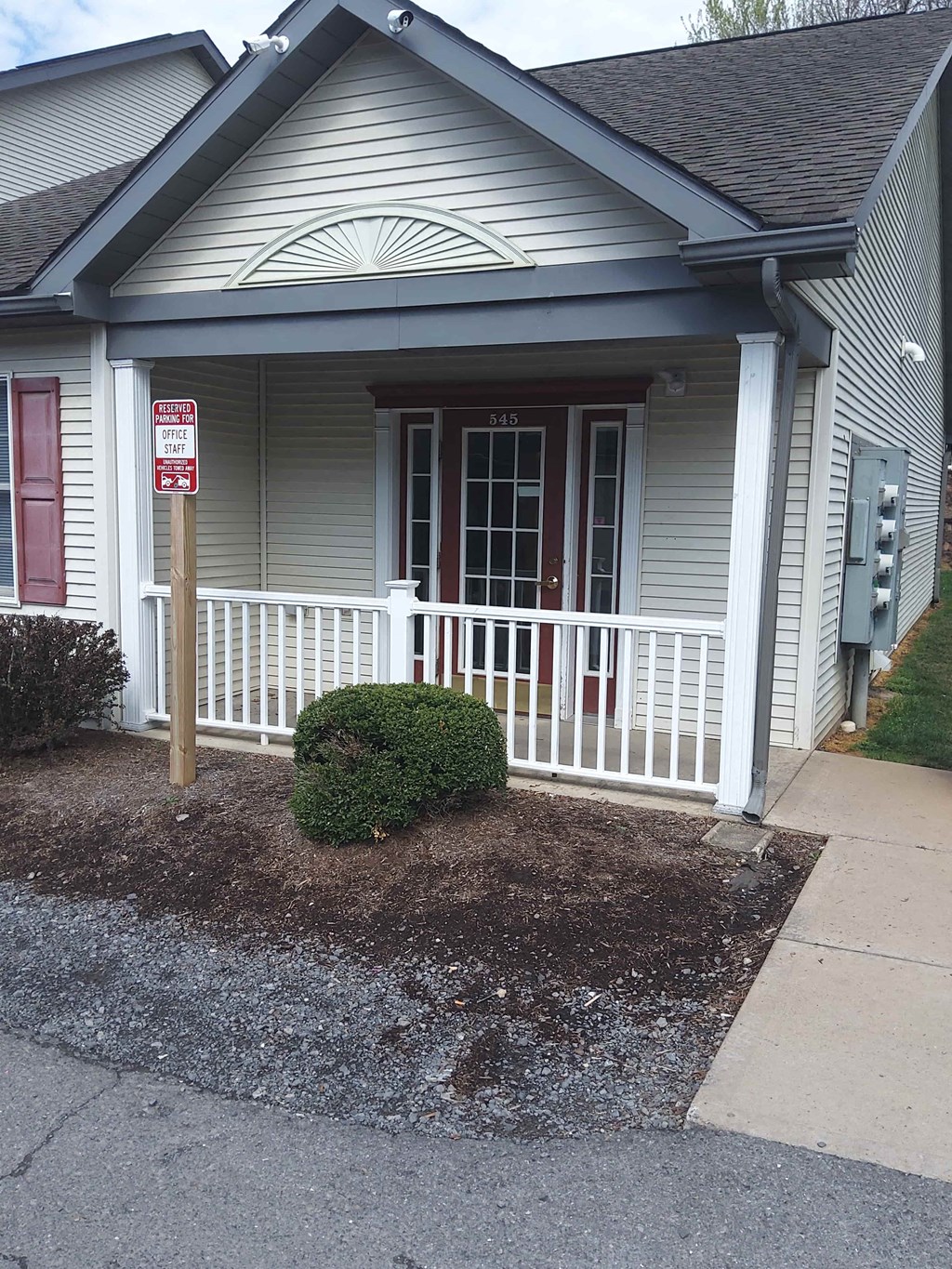a house with a porch and a sign on the side of it