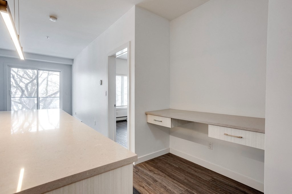 an empty kitchen with white cabinets and a white counter top