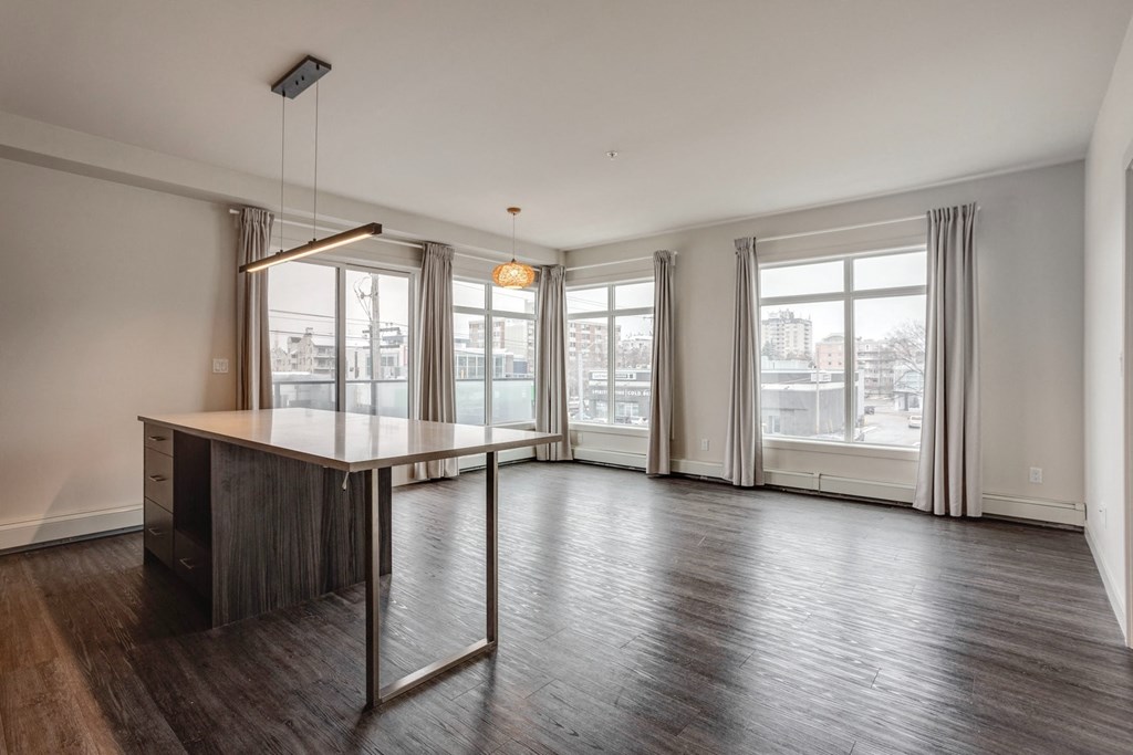 an empty living room with a large window and a table