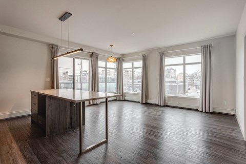 an empty living room with a large window and a table