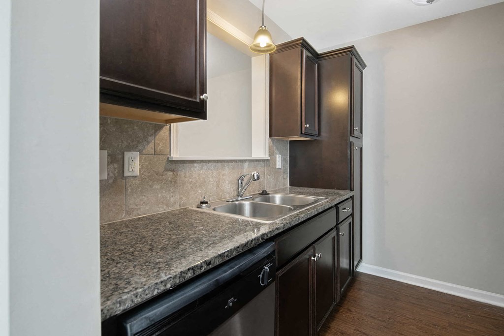 a kitchen with granite counter tops and a stainless steel sink