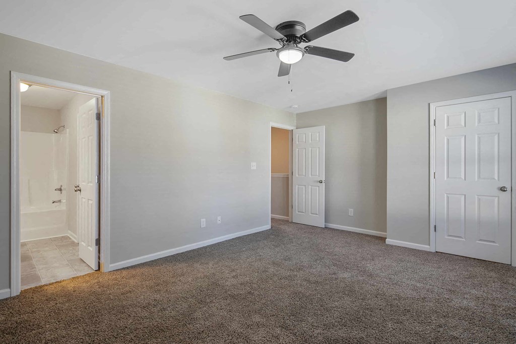 an empty living room with a ceiling fan