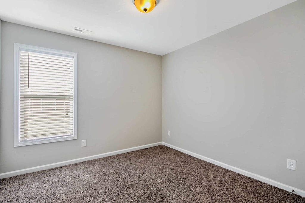 an empty room with carpet and a window