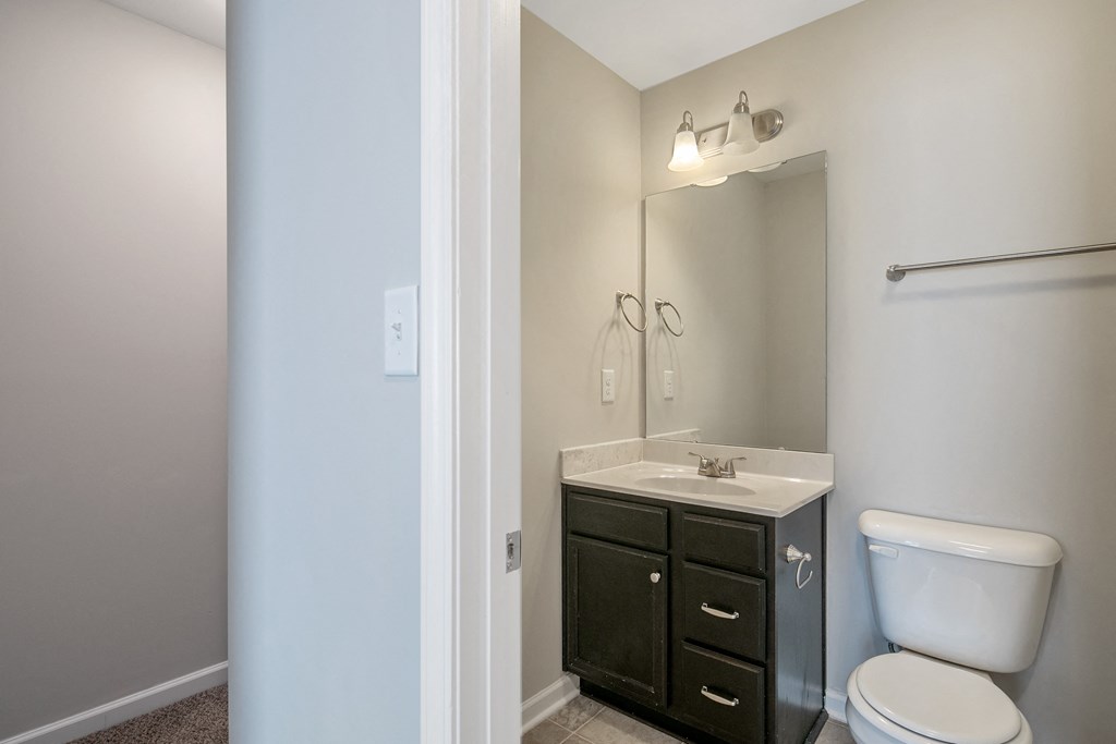 an empty bathroom with a toilet sink and mirror