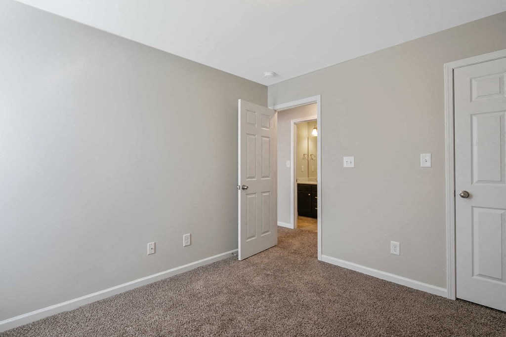 a bedroom with a closet and a door to a bathroom