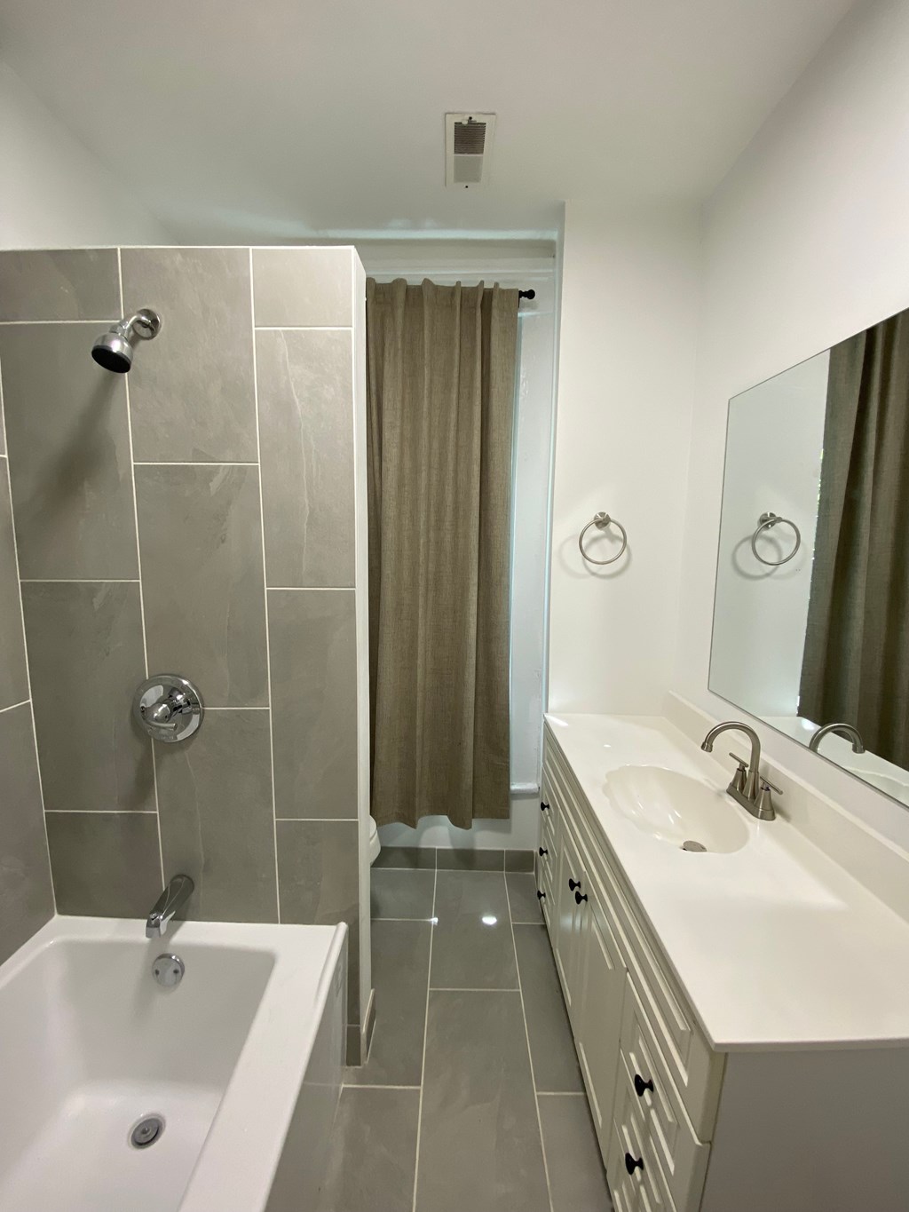 A bathroom with a white sink and a shower with a glass door.