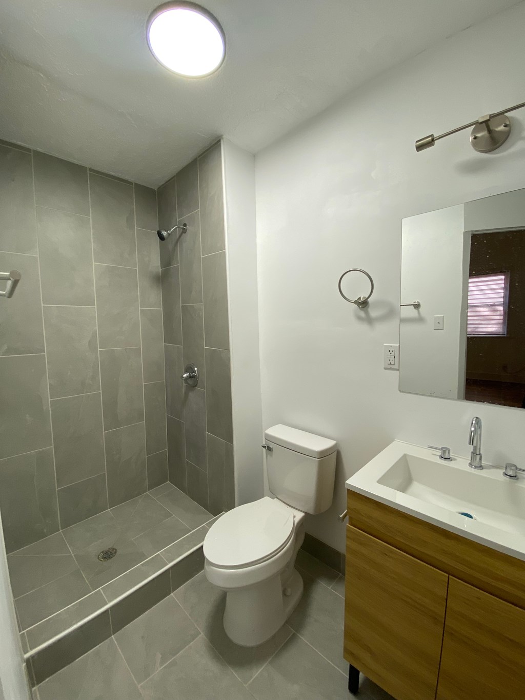 A bathroom with a toilet, sink, and shower.