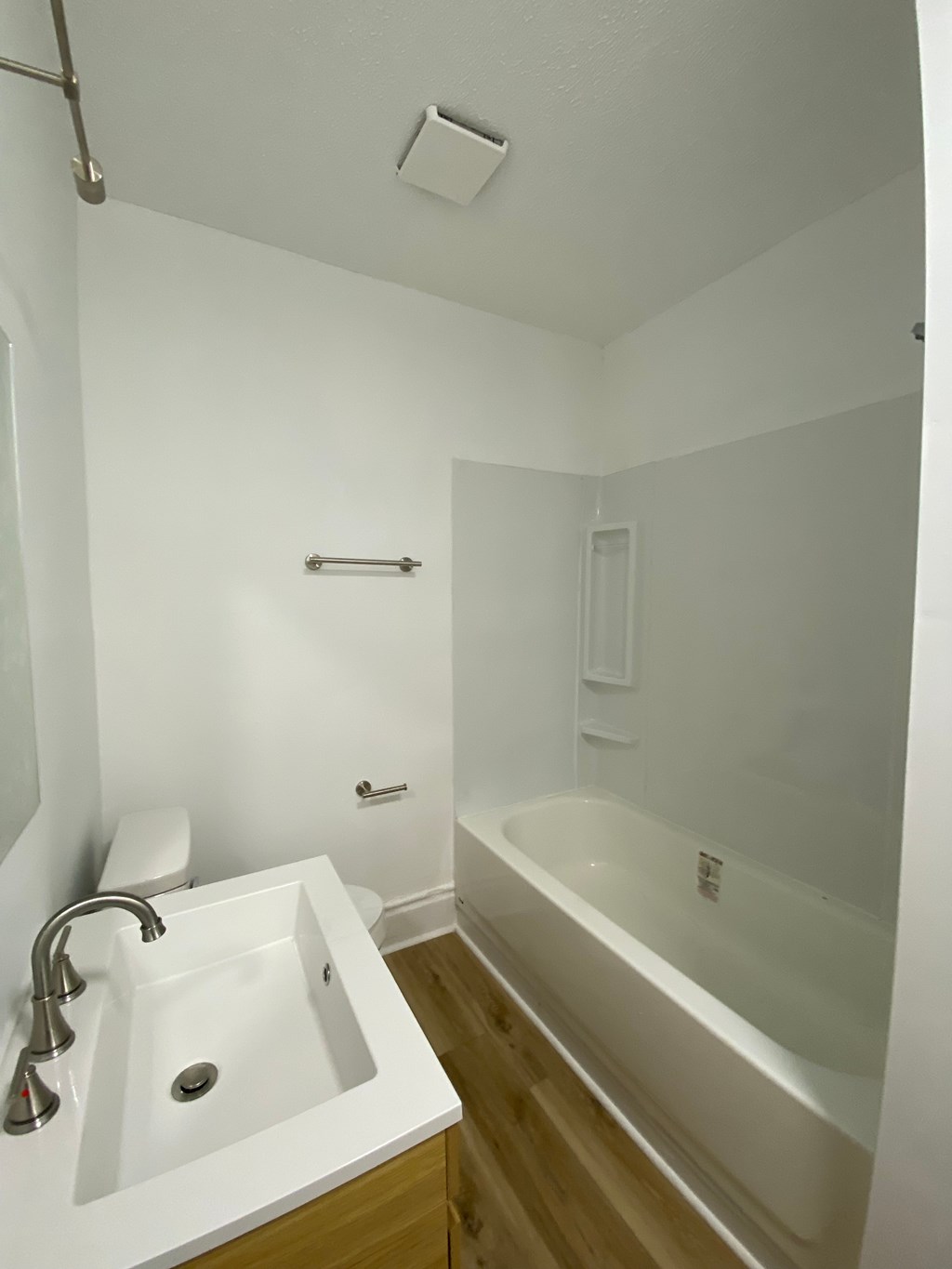 A white bathroom with a sink, toilet and bathtub.