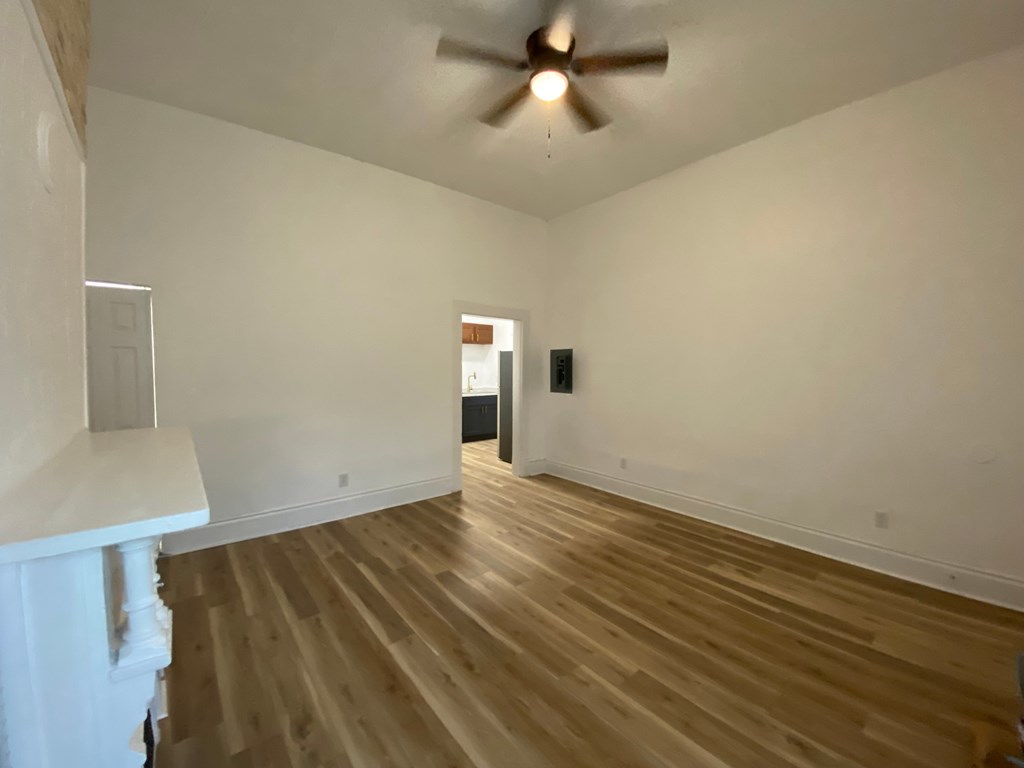 A room with wooden flooring and a ceiling fan.