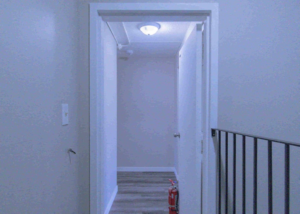 a hallway with stairs and a light on the ceiling