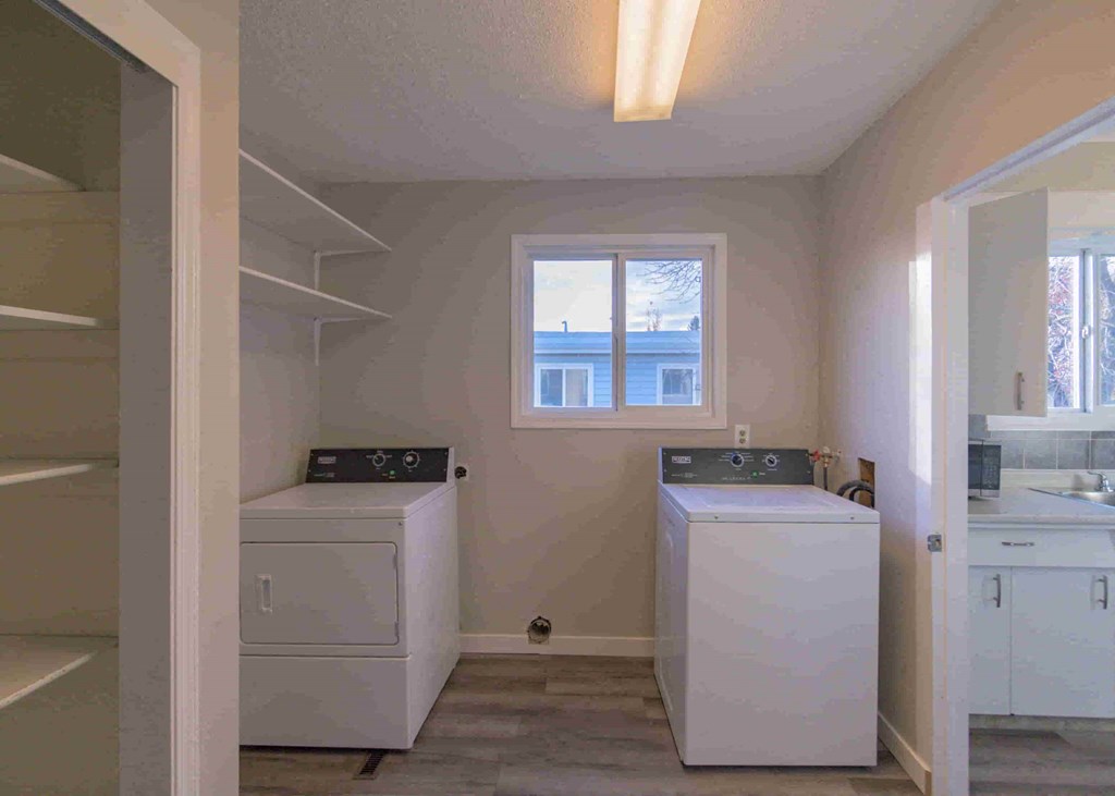 a laundry room with a washer and dryer and a window
