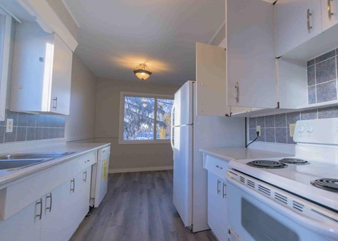 a kitchen with white appliances and white cabinets