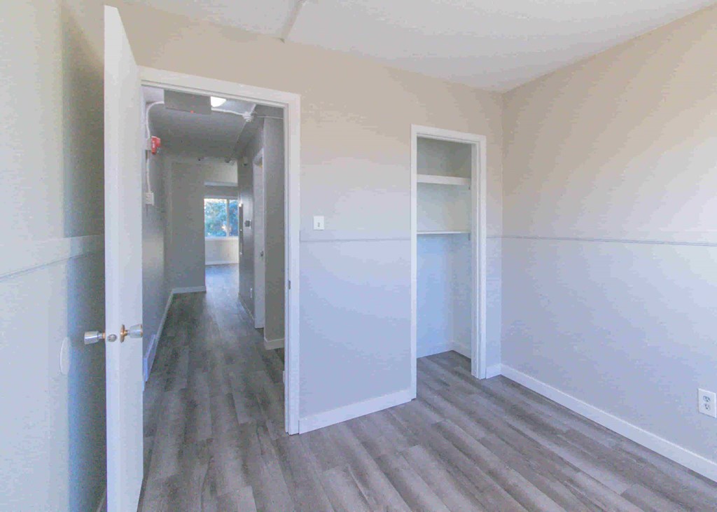 a bedroom with white walls and a hallway with white doors