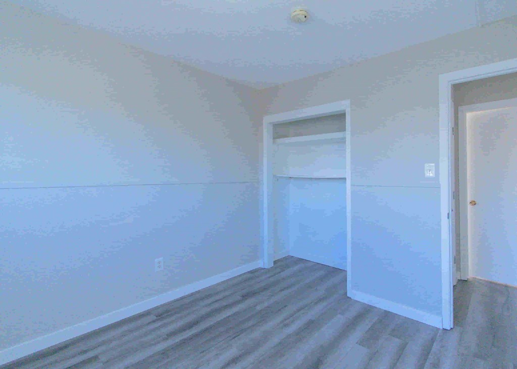 a room with white walls and a door to a closet