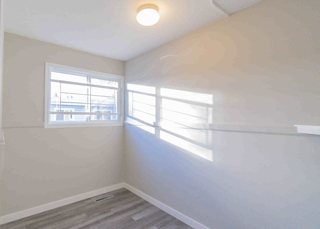 an empty room with white walls and a window