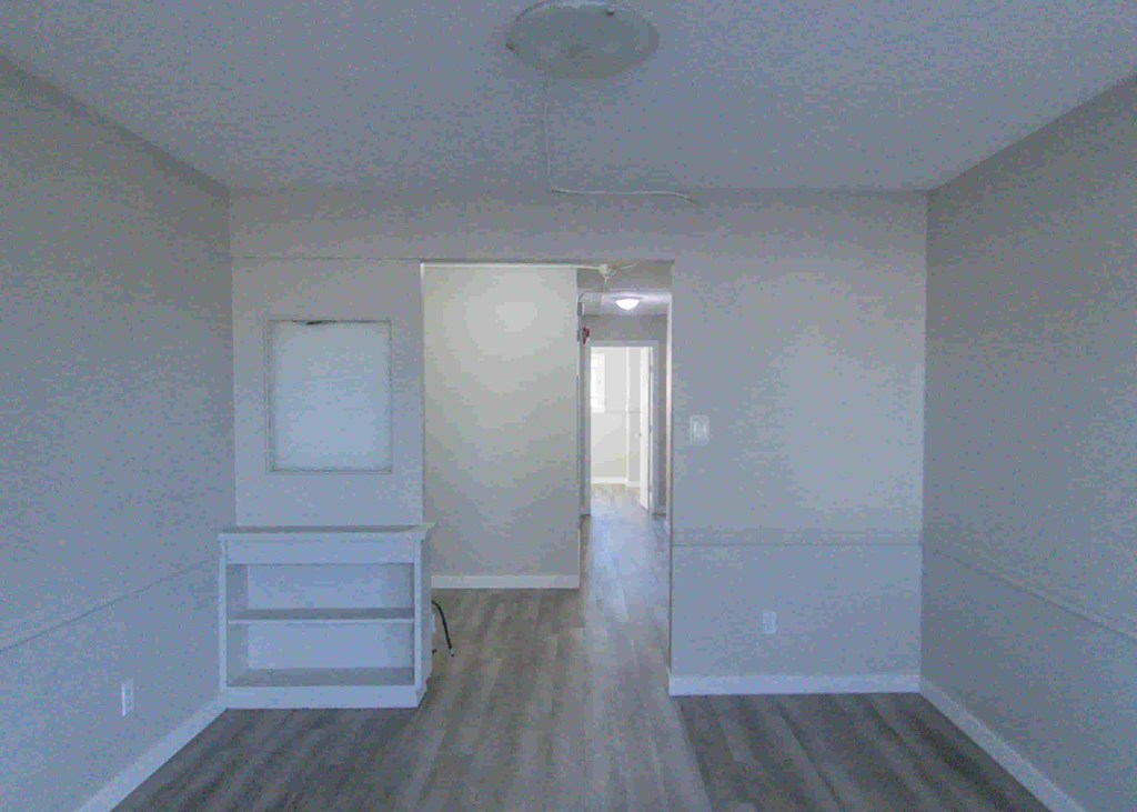 an empty room with white walls and a door to a hallway