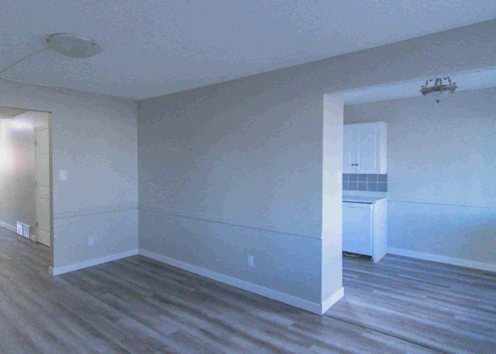 an empty room with white walls and a wooden floor
