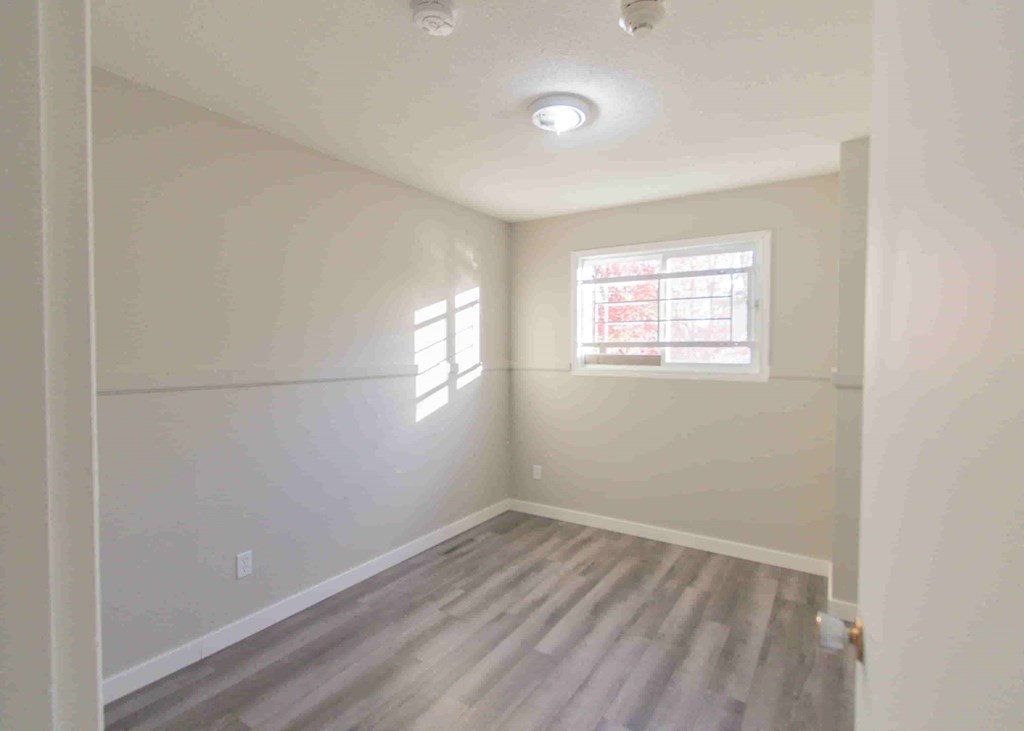 an empty room with white walls and a window