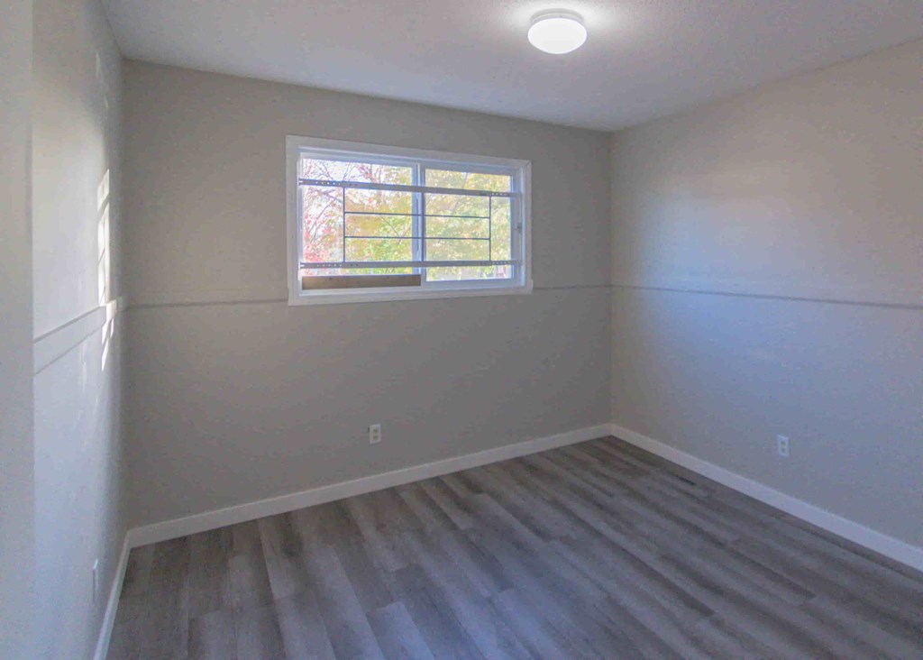 an empty room with white walls and a window