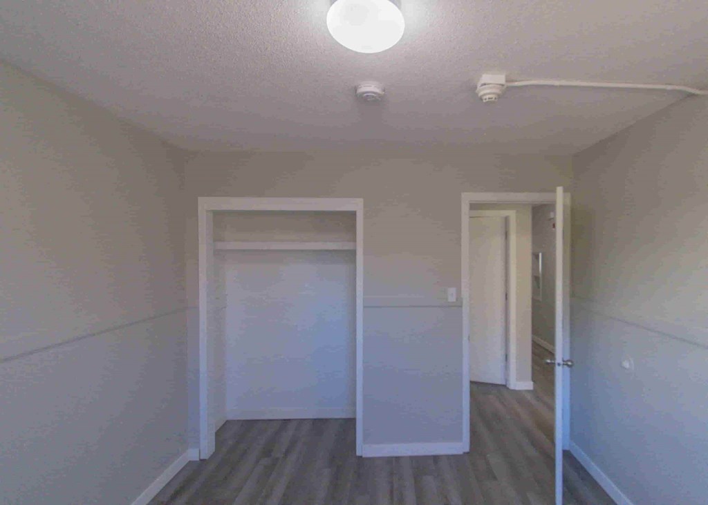 a room with white walls and a hallway with two doors and a ceiling light