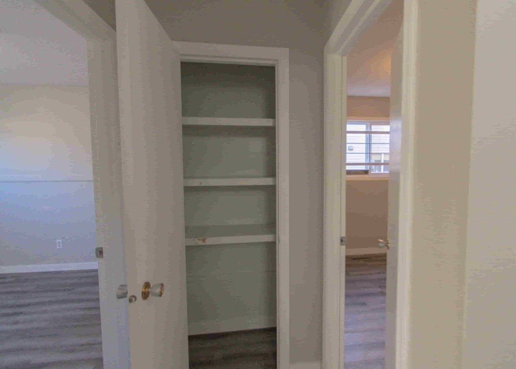an empty closet in a room with a door open