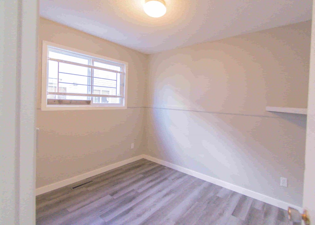 an empty room with white walls and a window