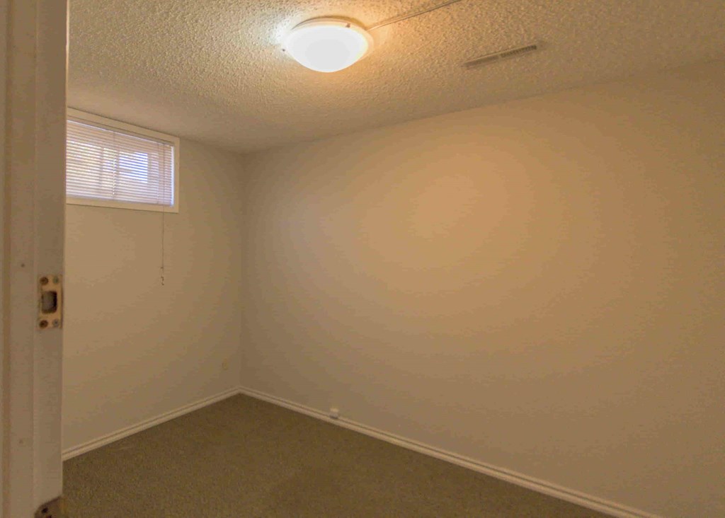 an empty room with a white wall and a white door