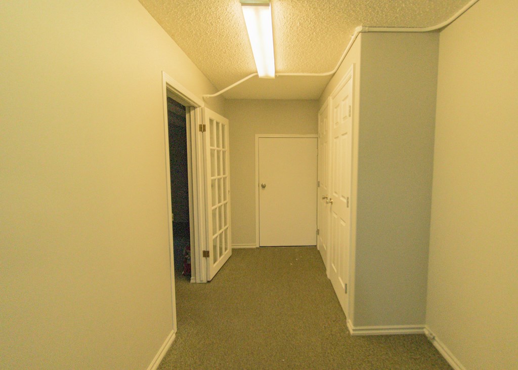 a room with a door to a closet and a door into a hallway